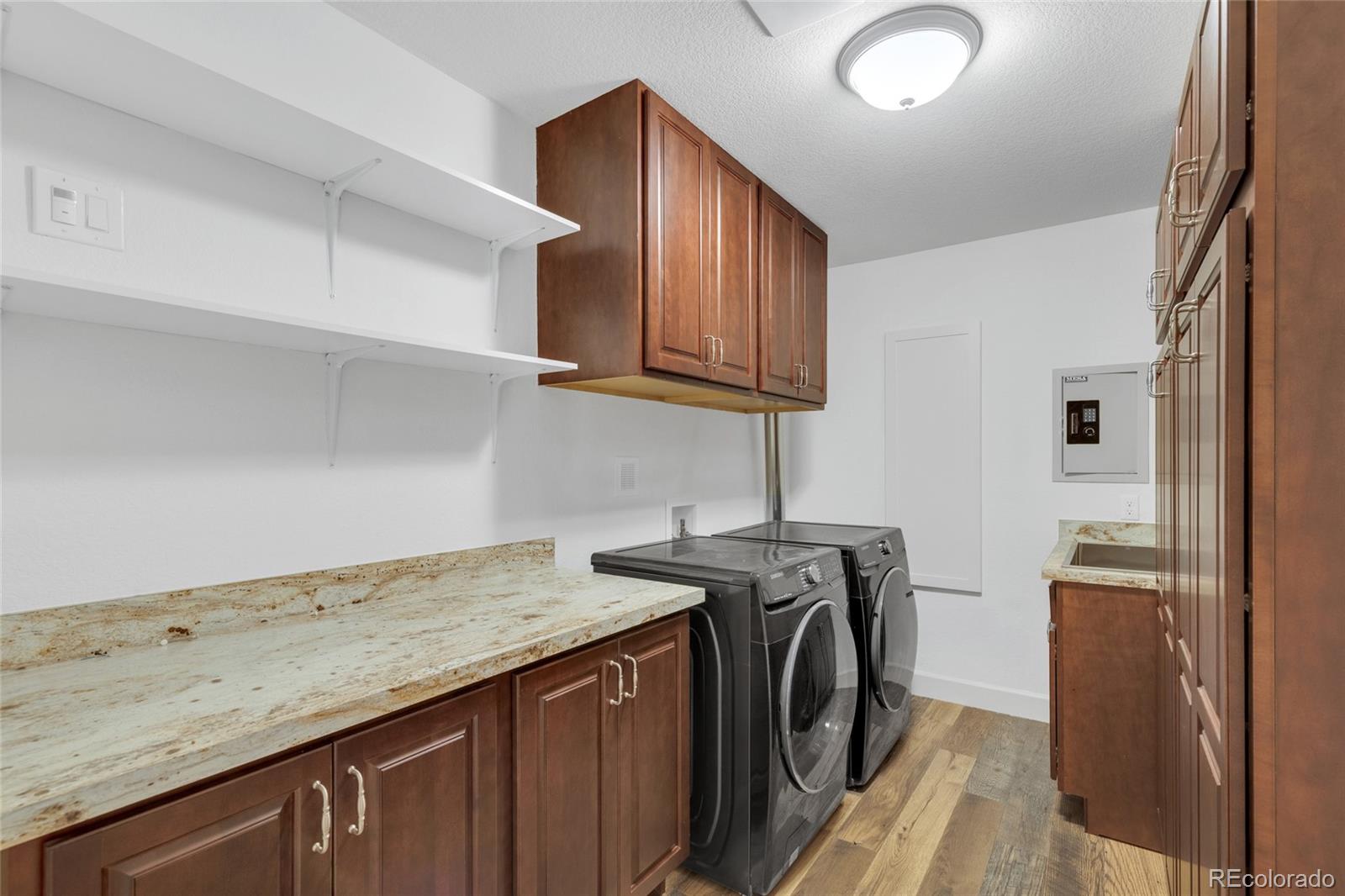 10632 Star Thistle Court Highlands Ranch, CO 80126 - Photo 25 of 50 a utility room with granite countertop a sink a washer and dryer