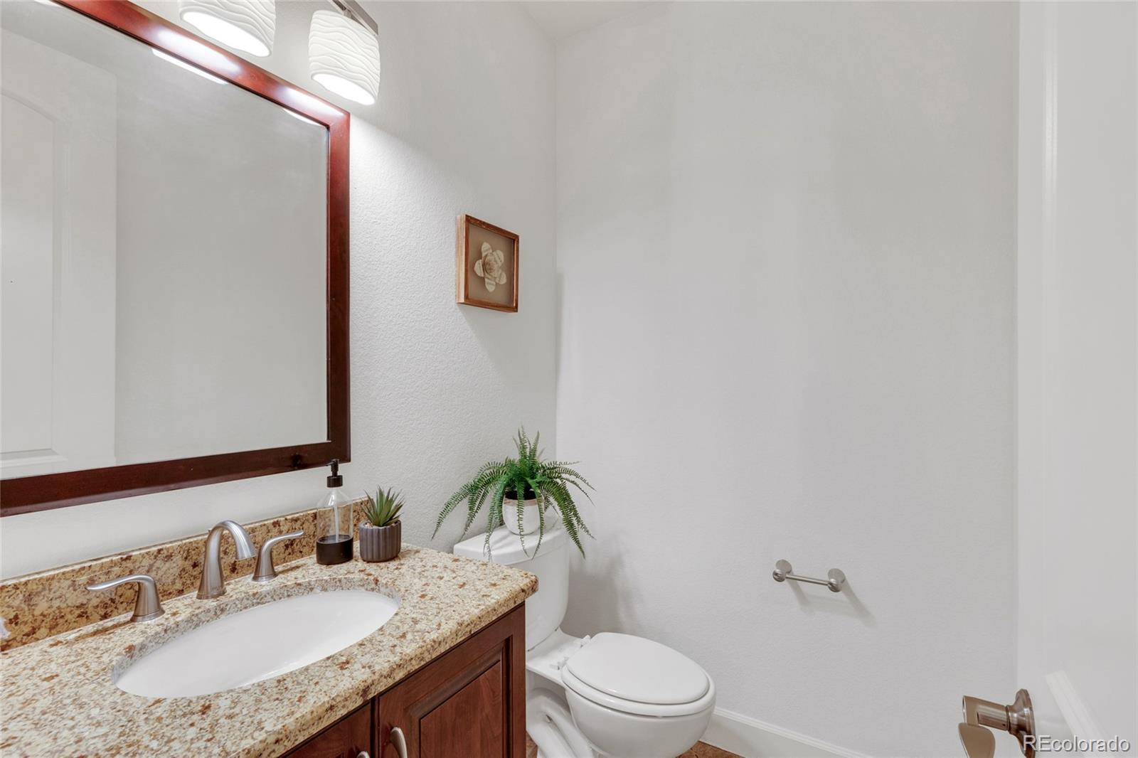 10632 Star Thistle Court Highlands Ranch, CO 80126 - Photo 35 of 50 a bathroom with a granite countertop sink a toilet and a mirror