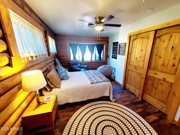 a bedroom with a bed window and wooden floor
