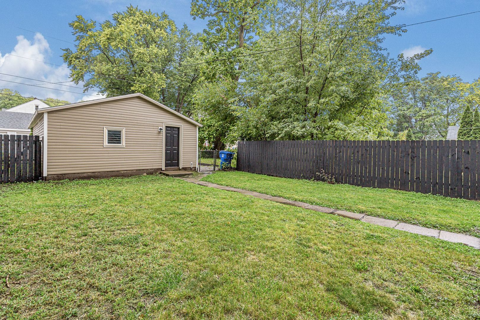 2522 5th Avenue Moline, IL 61265 - Photo 2 of 6 a backyard of a house with plants and large tree