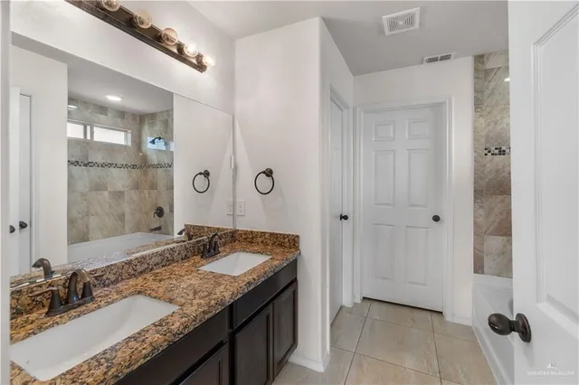 a bathroom with a granite countertop sink and a mirror