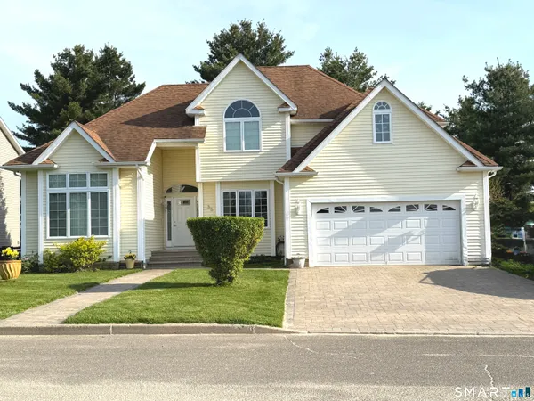 a front view of a house with a garden and plants