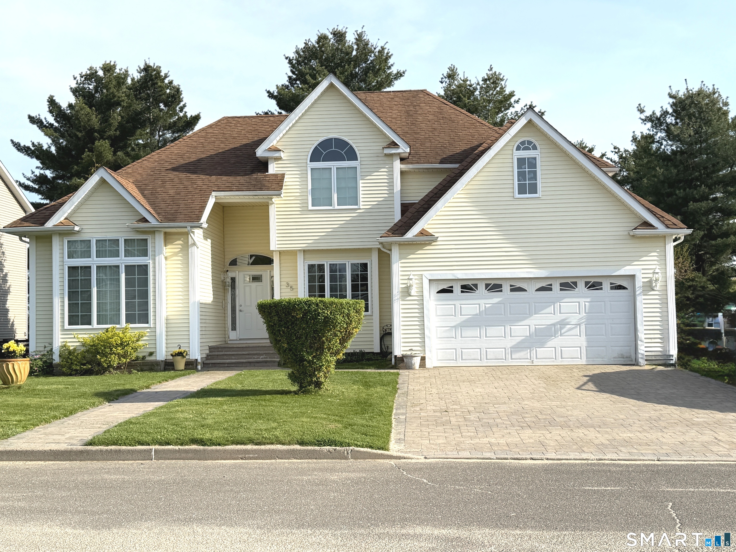 35 Emerald Pines Road Waterbury, CT 06704 - Photo 1 of 40 a front view of a house with a garden and plants