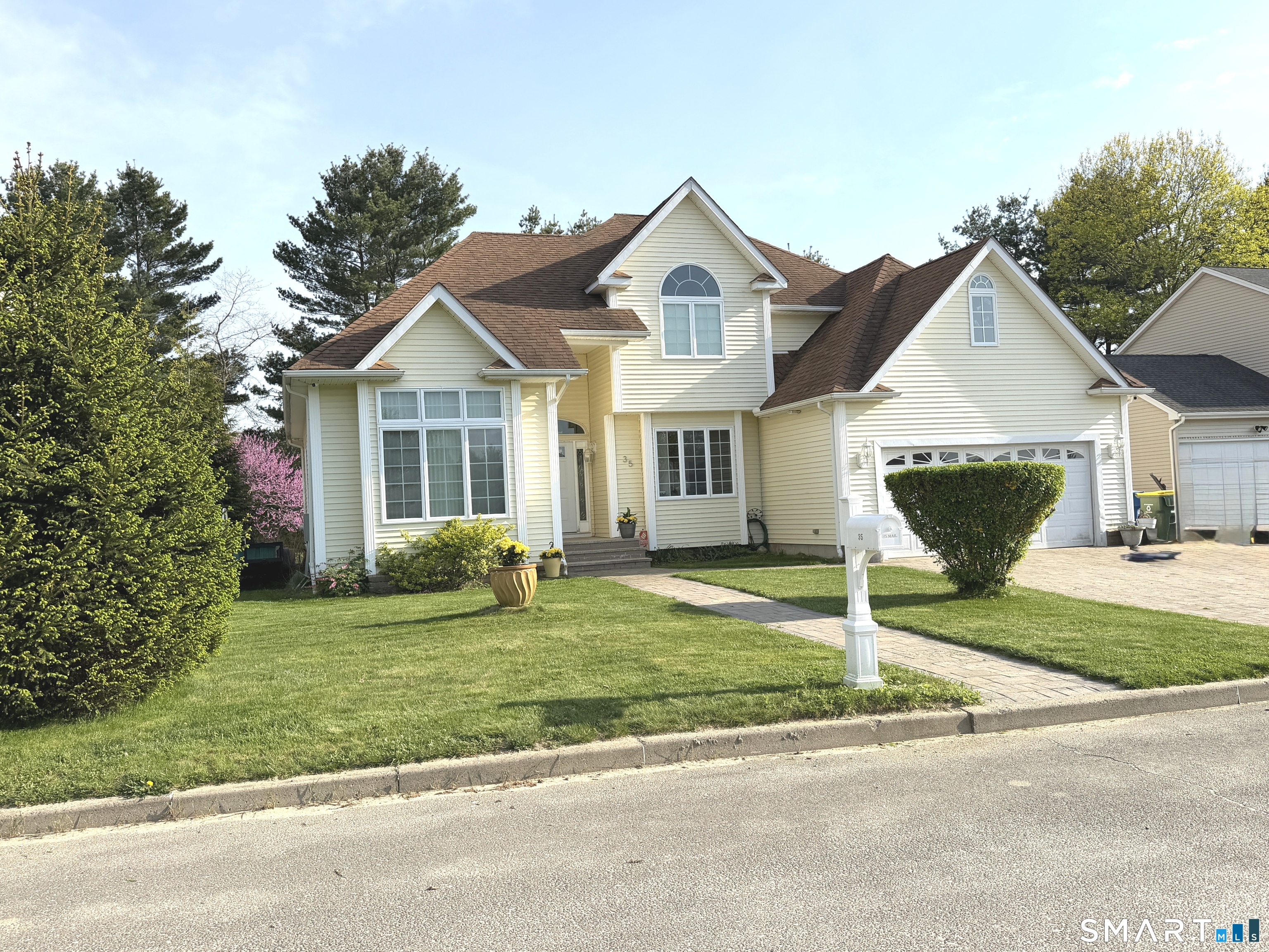 35 Emerald Pines Road Waterbury, CT 06704 - Photo 16 of 40 a front view of a house with a garden and yard