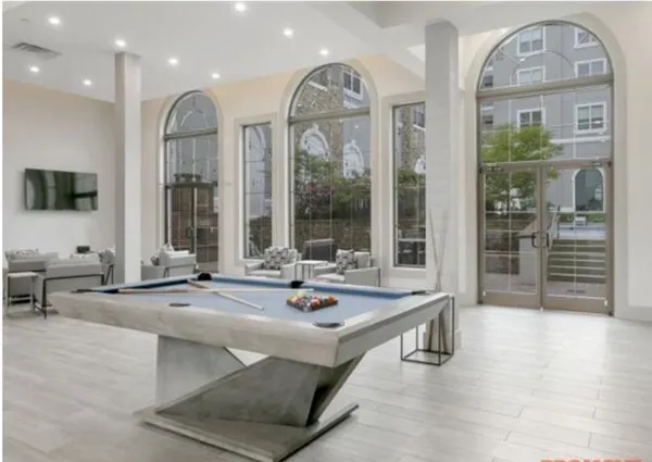 a view of living room filled with furniture and large mirror