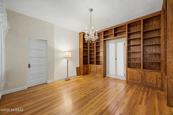 a view of empty room with wooden floor and cabinet