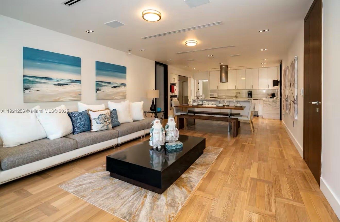 a living room with stainless steel appliances furniture and a table