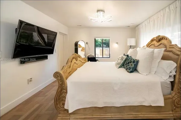 a bedroom with a bed and a flat screen tv