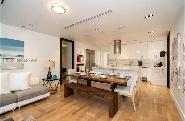 a living room with stainless steel appliances kitchen island granite countertop furniture and a couch