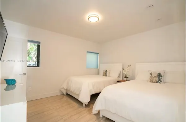 a bedroom with two beds and a lamp on the dresser