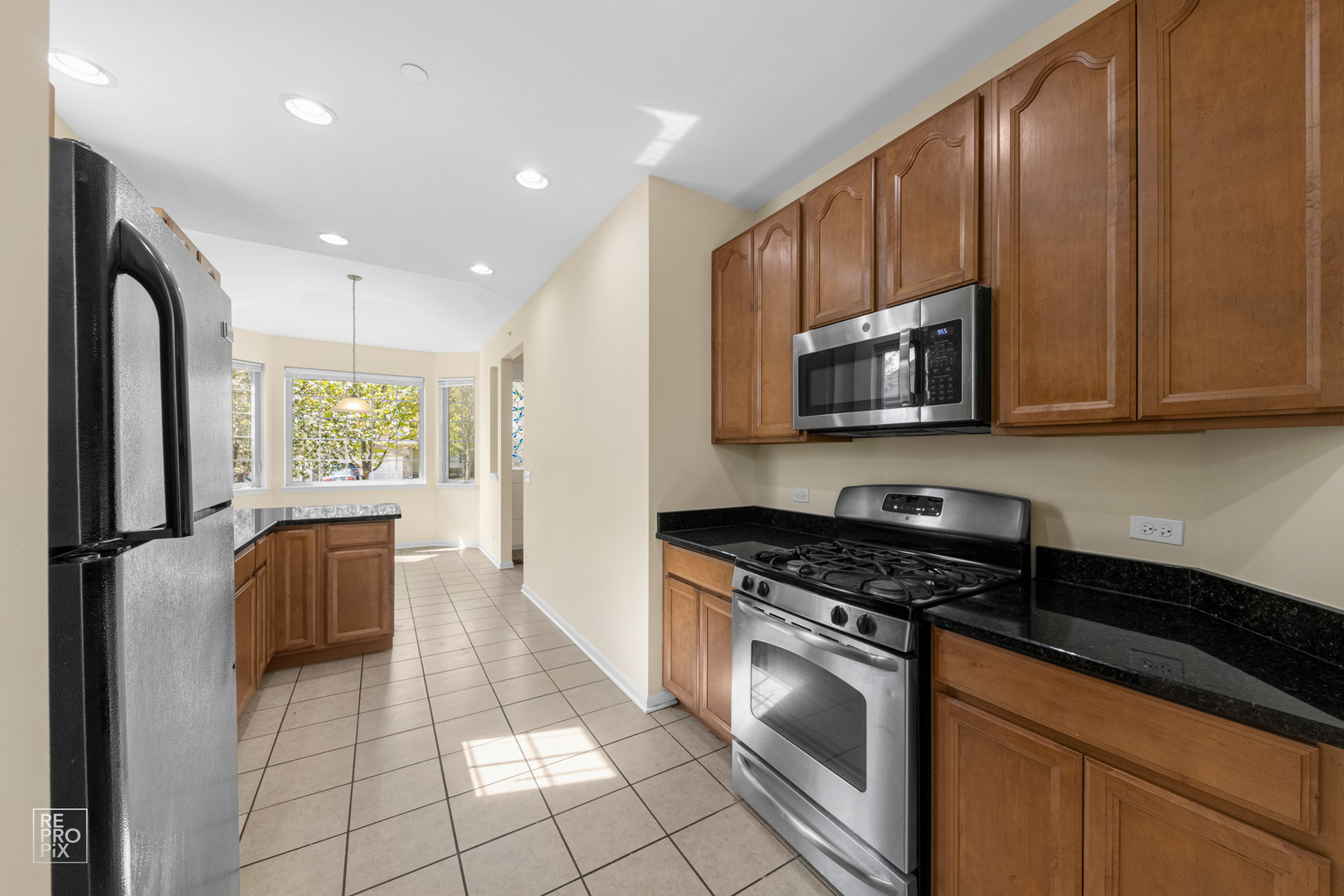 6400 Cunningham Court Gurnee, IL 60031 - Photo 7 of 19 a kitchen with granite countertop a stove a sink and a refrigerator
