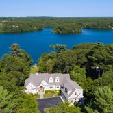 an aerial view of residential houses with outdoor space and lake view