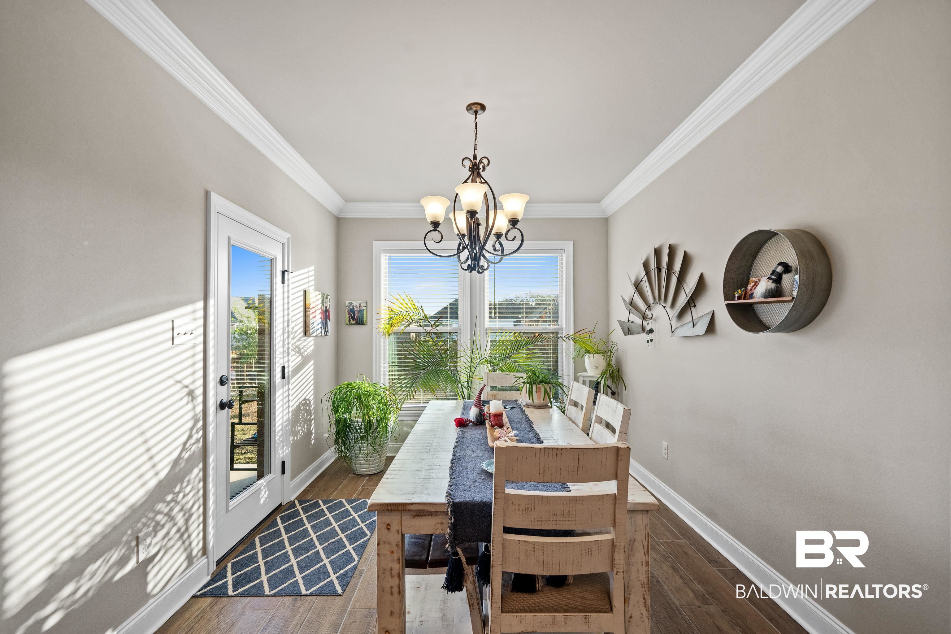 1390 Aldon Street Foley, AL 36535 - Photo 10 of 31 Dining space with crown molding, a chandelier, and hardwood / wood-style flooring