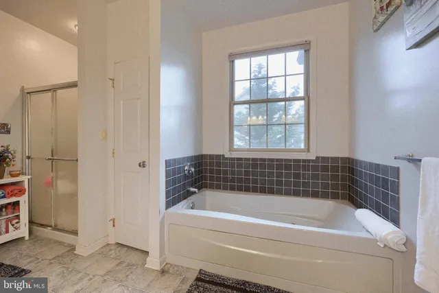 a bedroom with a bed and a potted plant on dresser