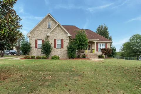 a view of a house with a yard and potted plants