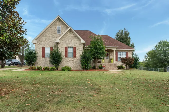 a view of a house with a yard and potted plants