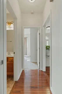 a view of a hallway with wooden floor and closet