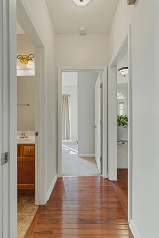 a view of a hallway with wooden floor and closet