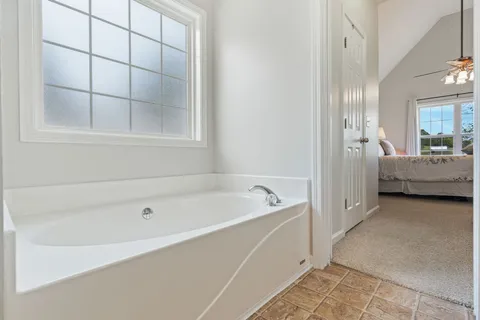 a bathroom with a tub a double vanity sink and shower