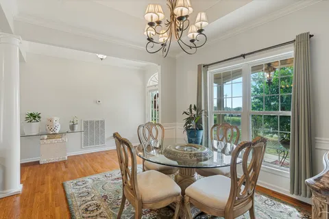 a view of a dining room with furniture wooden floor and chandelier