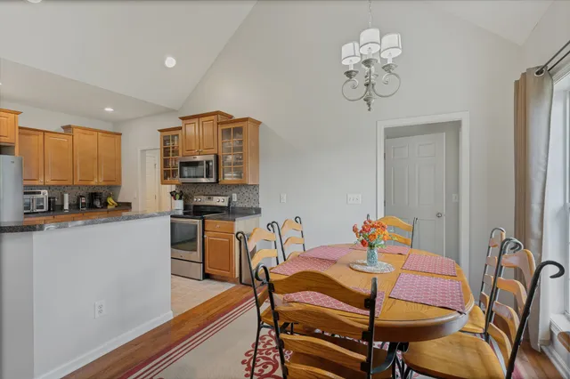 a view of a dining room with furniture a chandelier and wooden floor