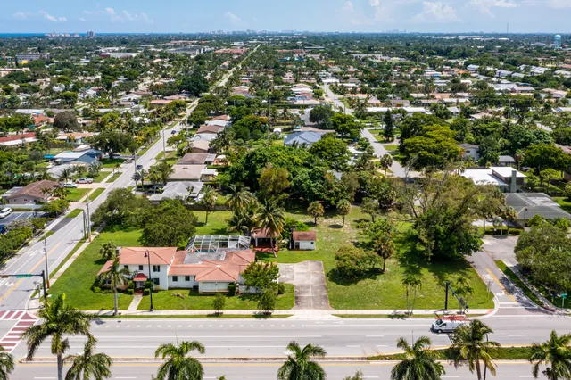 an aerial view of residential houses with outdoor space and trees
