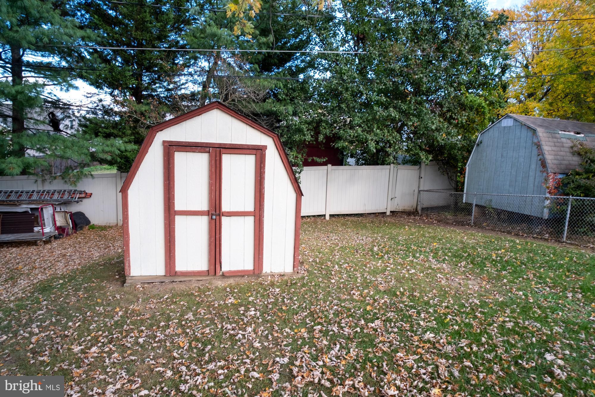 1200 Oakland Terrace Road Baltimore, MD 21227 - Photo 4 of 21 Charming backyard shed amidst autumn leaves.