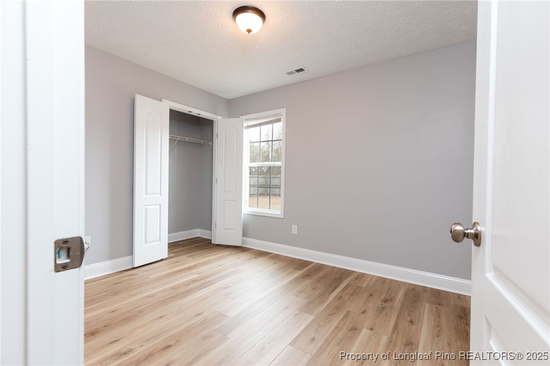 3192 Braddy Road Fayetteville, NC 28306 - Photo 12 of 20 an empty room with wooden floor and windows