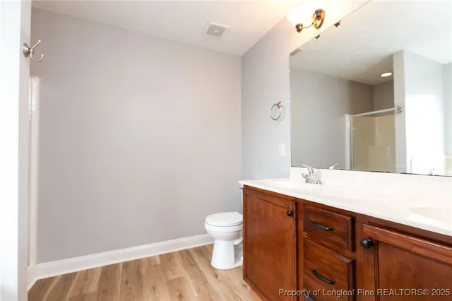 a bathroom with a granite countertop sink a toilet and a mirror