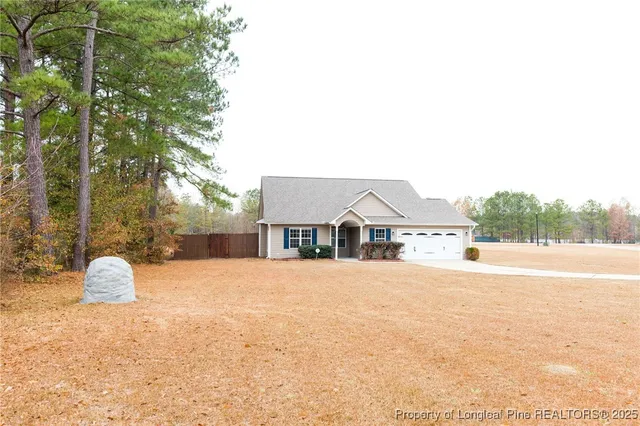 a front view of house with yard and trees around