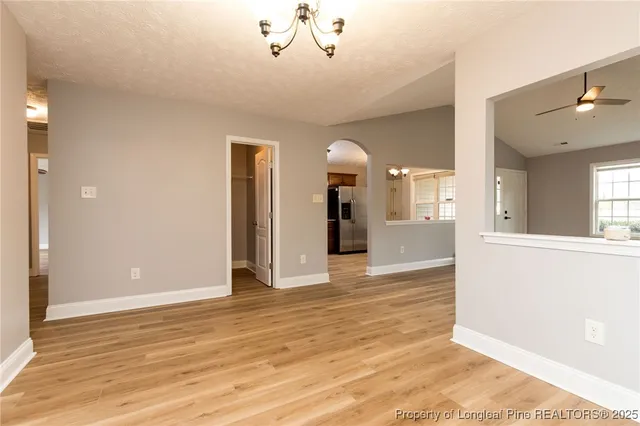 a view of an empty room and kitchen view