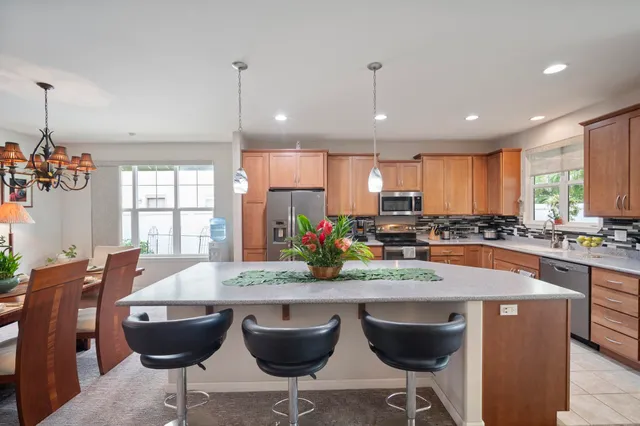 a kitchen with granite countertop a table chairs stove a sink and dishwasher
