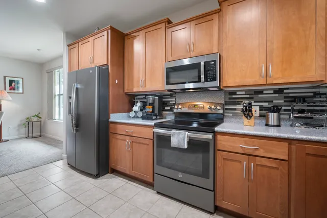 a kitchen with stainless steel appliances granite countertop a refrigerator stove and sink