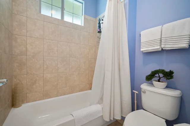 a bathroom with a toilet and a shower