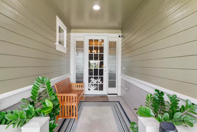 a balcony with potted plants and wooden bench