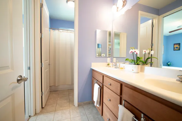 a spacious bathroom with a double vanity sink a mirror and a bathtub