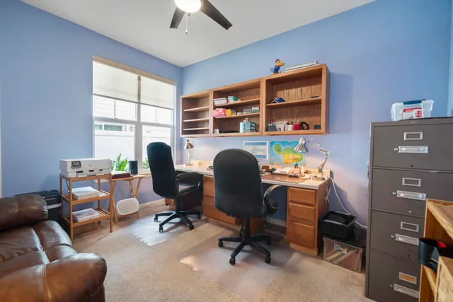 a view of a workspace with furniture and a window