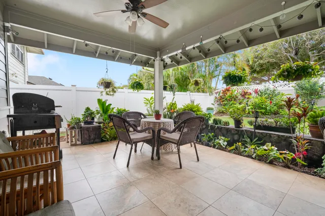 a patio with table and chairs and potted plants