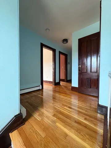 a view of an empty room with closet and wooden floor