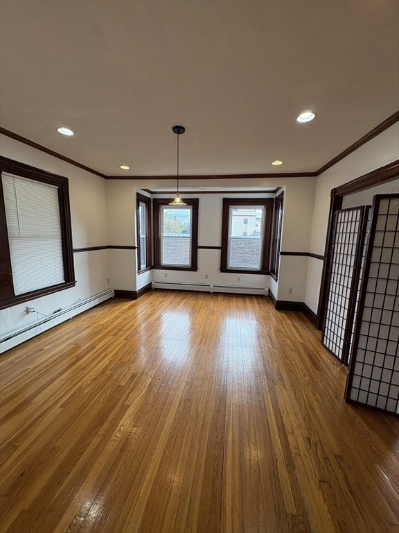 547 Talbot Avenue Boston, MA 02124 - Photo 4 of 14 a view of an empty room with wooden floor and a window