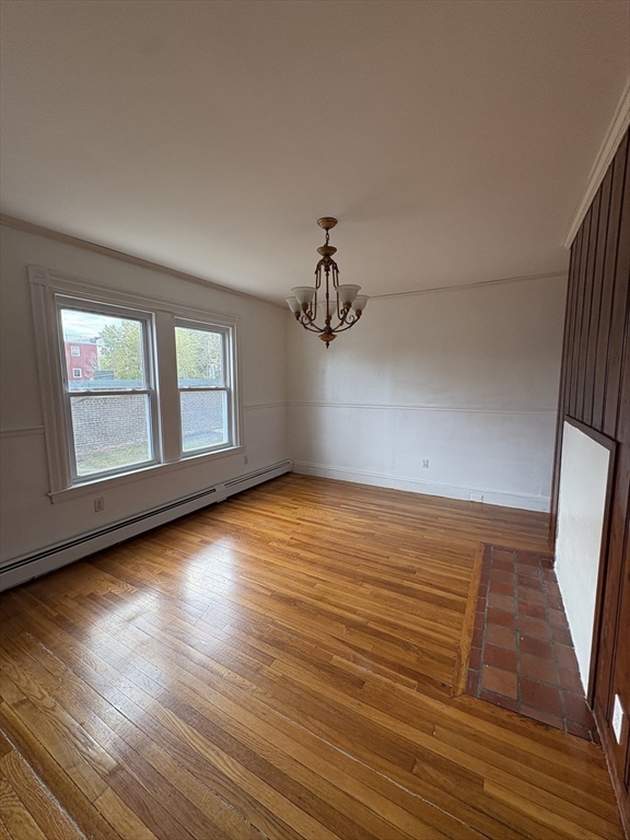 547 Talbot Avenue Boston, MA 02124 - Photo 9 of 14 an empty room with wooden floor and windows