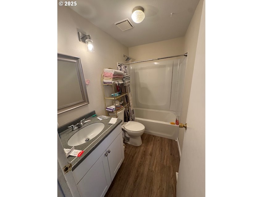 911 Division La Grande, OR 97850 - Photo 12 of 39 a bathroom with a granite countertop toilet a sink and mirror