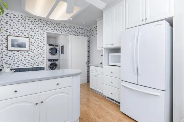 a kitchen with white cabinets and white appliances