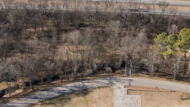 a view of a yard with wooden fence