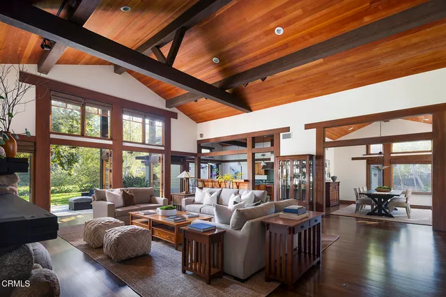 a living room with furniture a fireplace and a floor to ceiling window