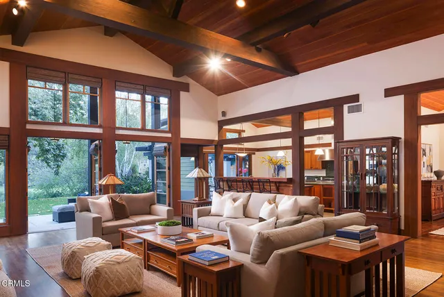 a living room with furniture a floor to ceiling window and floor to ceiling window