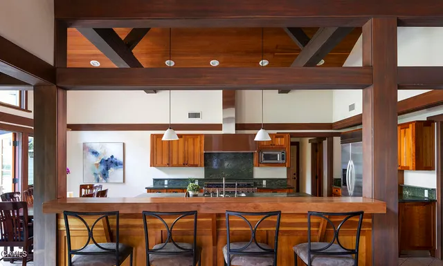 a kitchen with stainless steel appliances granite countertop a sink a stove and a wooden cabinets