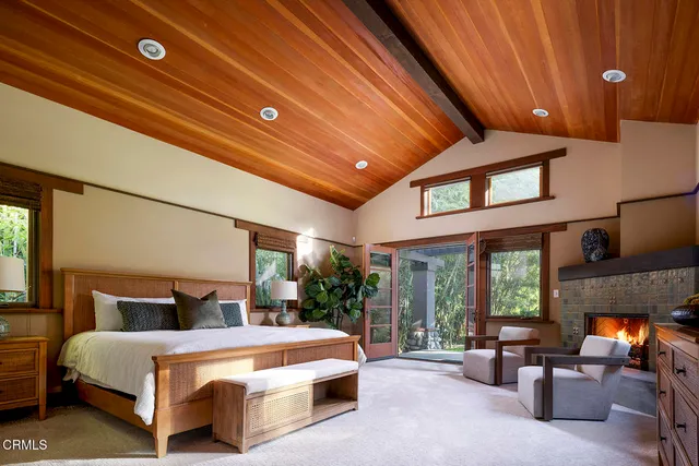 a bedroom with a bed and large windows