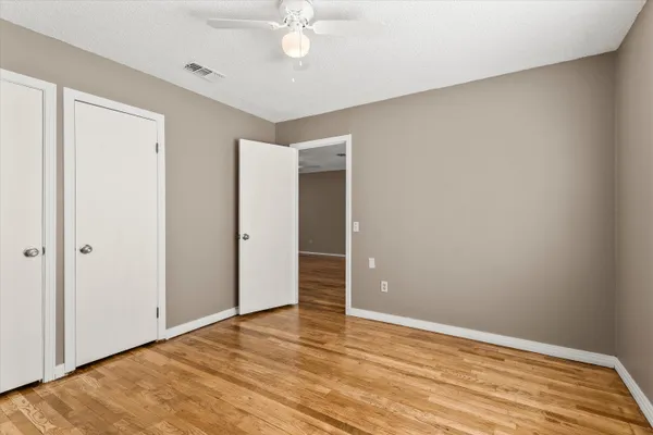a view of an empty room with wooden floor