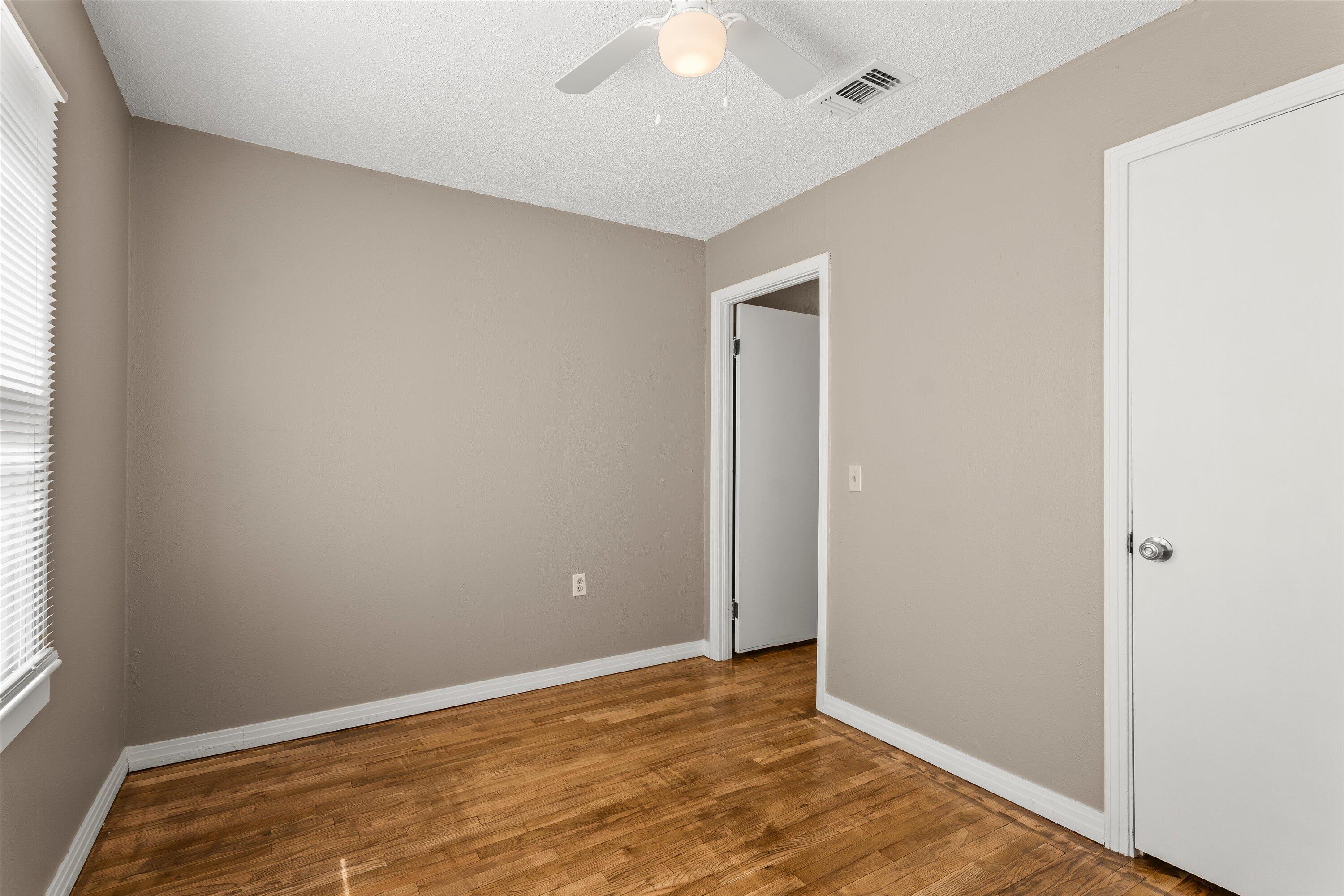 107 Hickory Street Levelland, TX 79336 - Photo 17 of 21 an empty room with wooden floor and windows